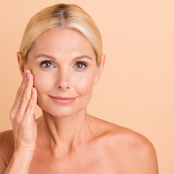 Blonde woman touching her face