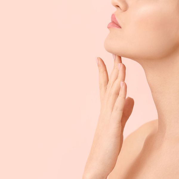 Woman touching the skin on her face.